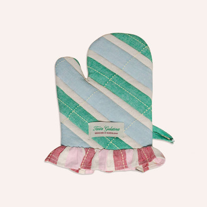 A striped oven mitt with diagonal bands of mint green, light blue, and cream, finished with a pink and cream ruffled hem. A white label on the front reads 'tarta gelatina'.
