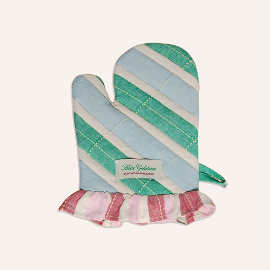 A striped oven mitt with diagonal bands of mint green, light blue, and cream, finished with a pink and cream ruffled hem. A white label on the front reads 'tarta gelatina'.