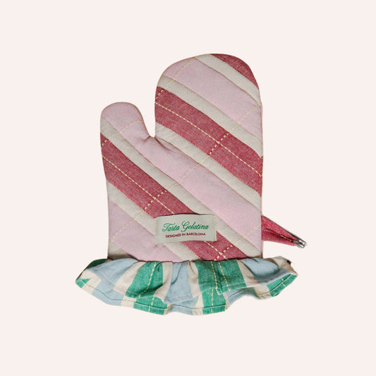 A quilted oven mitt with diagonal pink and cream stripes, featuring a ruffled trim at the bottom in green, blue, and cream stripes, with a visible 'tarta gelatina' brand label.